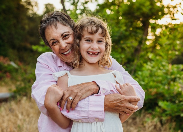 Grandmother and granddaughter hugging and smiling at camera